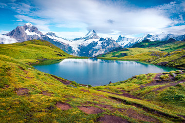 Picturesque summer view of Bachalpsee lake with Schreckhorn peak on background. Majestic morning scene of Swiss Bernese Alps, Switzerland, Europe. Beauty of nature concept background.