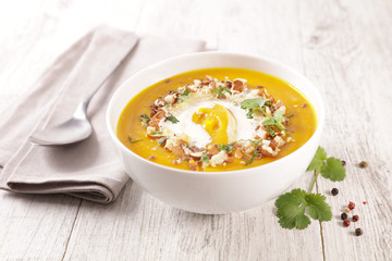 pumpkin soup with cream and nuts in bowl