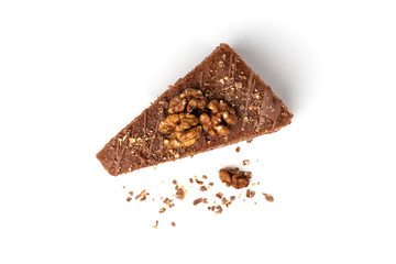 Slice of chocolate cake with milk filling and walnut isolated on white background.