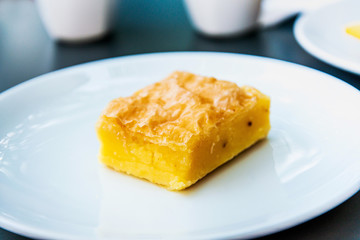 Delicious sweet orange cake, traditional greek pastry baked with orange pieces and honey, served in white plate.