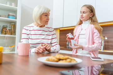 Calm senior lady staring at her grandchild