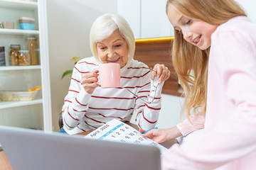 Senior lady sitting in front of her grandchild