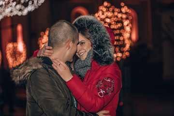 Cheerful couple in love is hugging, kissing and enjoying an intimate moment together, at night