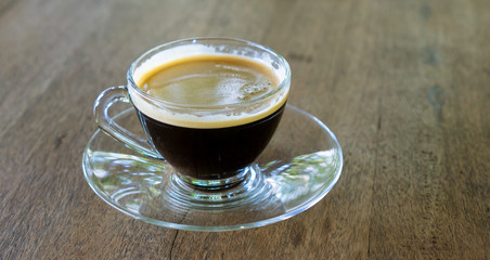 Hot coffee in a clear glass cup.
