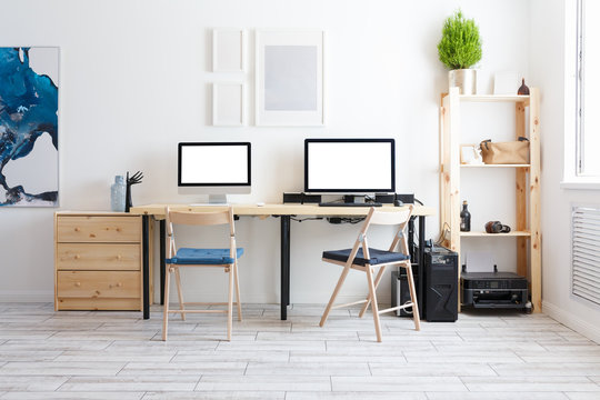 Beautiful cozy modern bright interior furniture made of natural materials and a workplace with two computers and monitors with a white screen. Home goods concept. Advertising space
