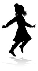 A child in silhouette playing in Christmas or winter cold weather clothing