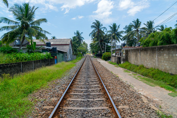 Fototapeta na wymiar Hikkaduwa, Sri Lanka. March 1, 2018. Railroad among tropical vegetation.