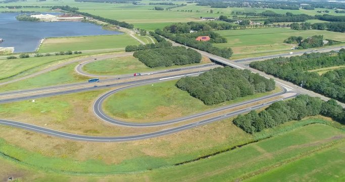 Fast Turning Shot of the A7 Highway on a Sunny Day, Exit 28, Near Drachten and Beetsterzwaag, Traffic consists of Cars, Trucks and a Blue Bus, Friesland, Netherlands / Holland &ndash; 4K Drone Footage