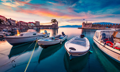 Sunrise in popular touristic destination - Nafpaktos port. Fantastic morning view of Gulf of Corinth, Greece, Europe. Fantastic seascape of Ionian sea. Traveling concept background.