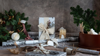 Christmas gift box, decor and fir tree branch on table.