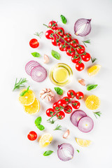 Cooking background with spices, vegetables and herbs fresh basil, rosemary, tomato, garlic, onions, lemon on a white kitchen table. Layout top view copy space. Healthy ingredients for cooking