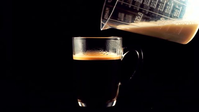Pouring Milk In Coffee Slow Motion.Barista Pouring Milk In Coffee For Cappuccino.Cream Pouring Into Espresso In Slow Motion.Adding Cream To Tea.