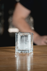 Big piece of ice in a cocktail glass on a black background