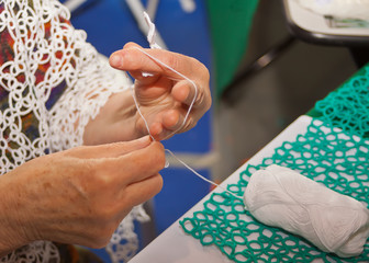 Senior woman knitting lace shawl at home