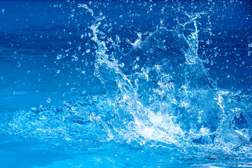 Splashes of clear blue fresh water in pool, air bubbles, water drops, sea wave with sunny...