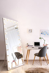 Large mirror with light bulbs in stylish room interior