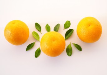 Above of ripe oranges are bright yellow with green leaves isolated on white background.