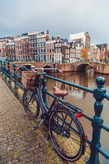Fototapeta premium Bicycle parked on a bridge in Amsterdam, Netherlands