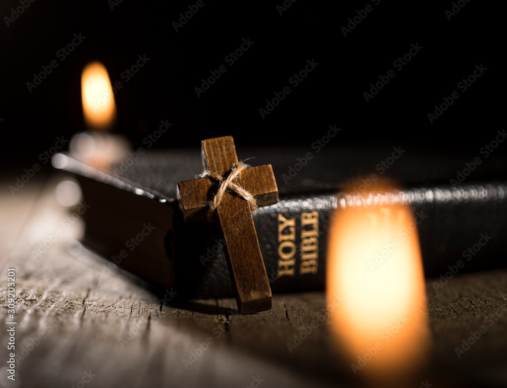 Wall mural holy bible and wooden cross on dark background