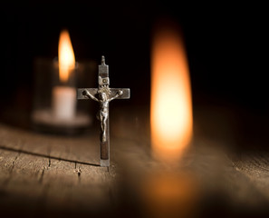Metal cross and candles on dark background