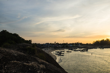 sunset on the beach with little boats