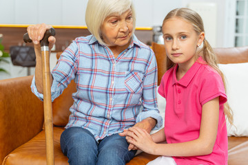 Obraz premium Loving grandchild sitting with her grandmother indoors