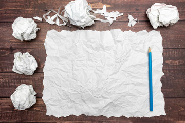 top view of pencil on a sheet of white wrinkled paper and crumble paper balls. inspiration,...