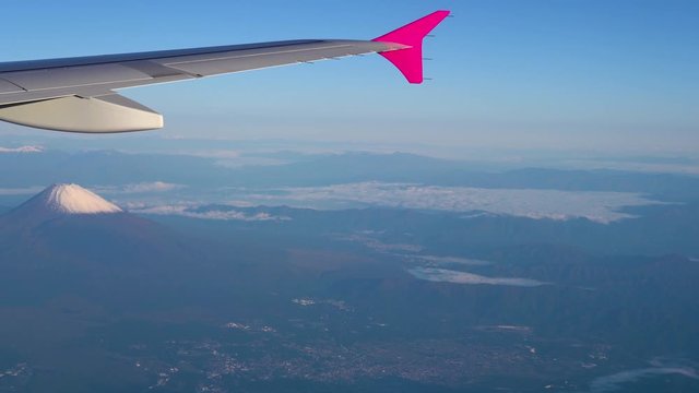 Aerial view of airplane wing with Mount Fuji ( Mt. Fuji ) in background and blue sky. Scenery landscapes of the Fuji-Hakone-Izu National Park. Gotemba city, Shizuoka Prefecture, Japan
