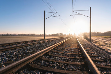 Fototapeta na wymiar Railroad tracks and frosty landscape. Rail tracks at sunrise