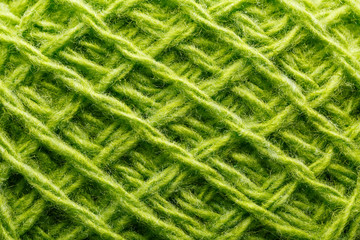 Wool yarn close up colorful green threads for needlework in macro.