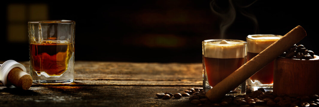 Irish coffee - coffee and whiskey and cigars against dark background