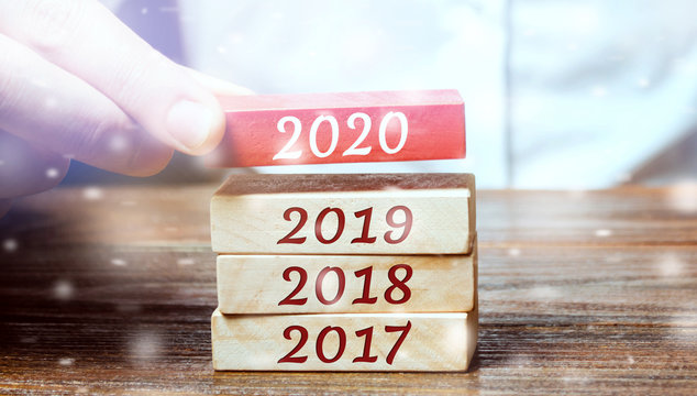 Businessman builds wooden blocks 2020. The concept of the beginning of the new year. New goals. Next decade. Trends and changes in the world. Build plans and planning. Time report. Snow, snowfall