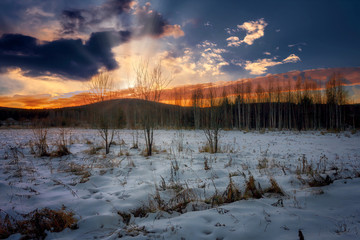 Colorful sunset in the winter forest. Beautiful winter landscape in the mountains. Sunrise.