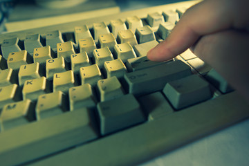 Old personal computer with man Entering Enter Button a keyboard. Ancient concept