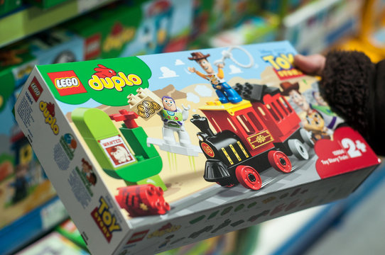Mulhouse - France - 7 December 2019 - Closeup of toy story train by  lego duplo in hand of woman in a toy store supermarket