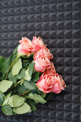pink roses bouquet on gray acoustic foam background
