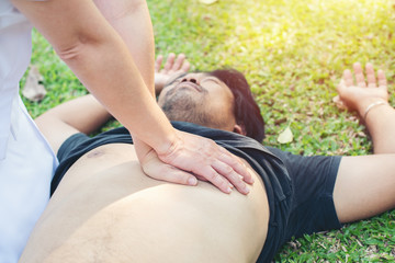 nurse giving cardiopulmonary resuscitation to man on grass park