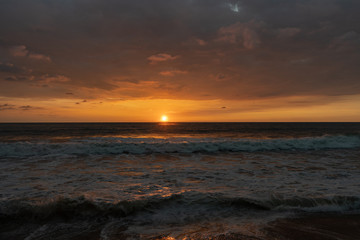 Panoramic view of sunset in ocean. Nothing but sky, clouds, beach and water. Beautiful serene scene