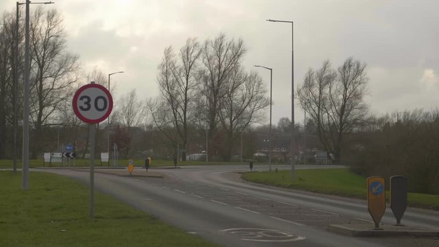 Empty road in England at dusk in winter. Speed limit and roundabout.