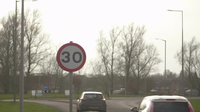 Pan to speed limit sign at dusk in English countryside.