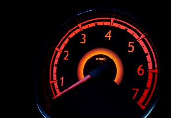 Red illuminated tachometer. Car interior.