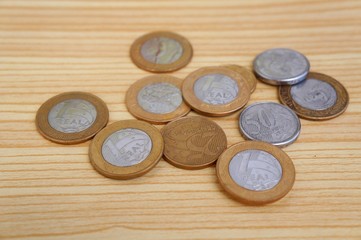 Brazilian Real coins on wooden background.