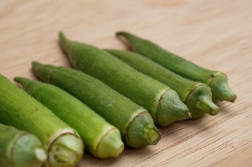 Close up of fresh okras on wooden background.