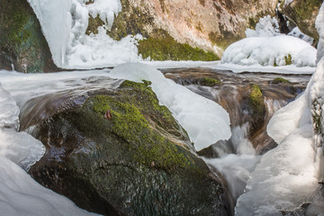 wasserfall mit eis schnee und felsen
