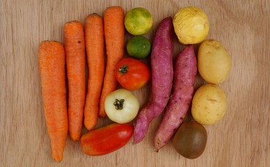 Carrots, potatoes, sweet potatoes, limes, tomatoes and kiwi fruit. Healthy life concept.