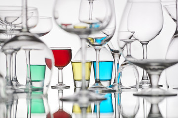 different glasses with colorful drinks on a white background
