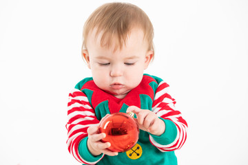 baby in elf costume grabbing a christmas balls