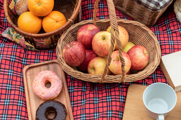 Naklejka na ściany i meble Summer time.Closeup of picnic basket with food and fruit in nature.