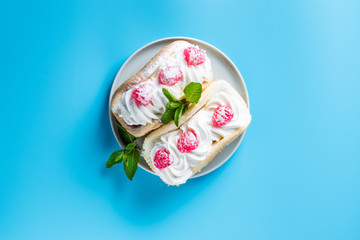 Obraz na płótnie Canvas Cake with raspberries and sprinkles on a blue background