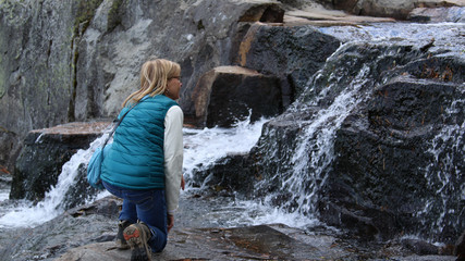 Lady kneeling down admiring the water falls